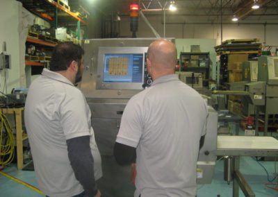 Technicians servicing food x-ray equipment