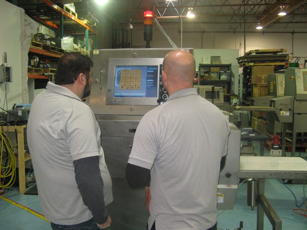 Técnicos dando servicio a equipos de rayos X para alimentos.